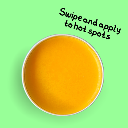 Top down aerial photo of open tin of Pulp Friction by SKIN LOLLI. it shows the product is orange coloured. The words, swipe and apply to hot spots is written on the side