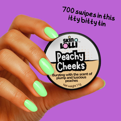 Hand holding a container of 'Peachy Cheeks' by skin LOLLI solid perfume against a purple background